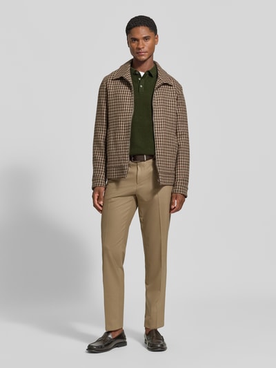 Männermodel trägt Strickpullover mit Polokragen und Knopfleiste von Fynch-Hatton in Grün, kombiniert mit beiger Hose und brauner Jacke, Reine Baumwolle, Regular Fit, Label-Stitching, Ganzkörperansicht von vorne.