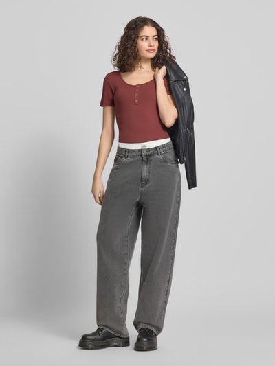 Kobiece modelka nosi Slim Fit T-Shirt aus Baumwoll-Mix Modell 'KITTE' od Pieces, jednolity kolor, krój slim fit, dekolt łódkowy, rib, krótkie rękawy, widok całej sylwetki z przodu.