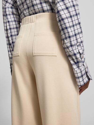 Frauenmodel trägt Wide Leg Sweatpants mit Eingrifftaschen von Rich & Royal in Beige, elastischer Bund, Modal-Mix, Detailaufnahme Rückansicht.