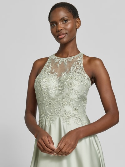 Kobieta modelka nosi sukienkę wieczorową 'Abendkleid mit floralem Stitching' od Luxuar w jasnym odcieniu, z półprzezroczystym materiałem, haftem w kwiatowy wzór, krój taliowany, obszycie ozdobnymi kamieniami, bez rękawów, szerokość w rozmiarze 36: 40 cm, długość tyłu w rozmiarze 36: 157 cm; półzbliżenie górnej części ciała z przodu.