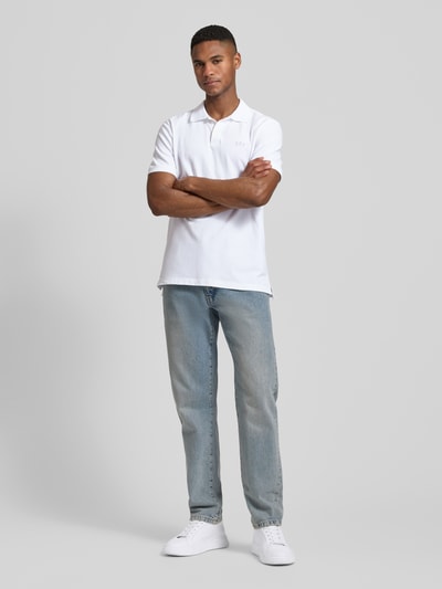 Männermodel trägt weißes Slim Fit Poloshirt mit Label-Stitching von GAP aus Baumwoll-Elasthan-Mix, Ganzkörperansicht von vorne