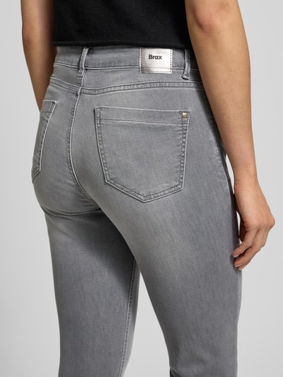 Frauenmodel trägt Skinny Fit Jeans mit Eingrifftaschen Modell 'SHAKIRA' von Brax in grauer Used-Look Baumwoll-Lyocell-Mischung, Detailaufnahme Rückenansicht.