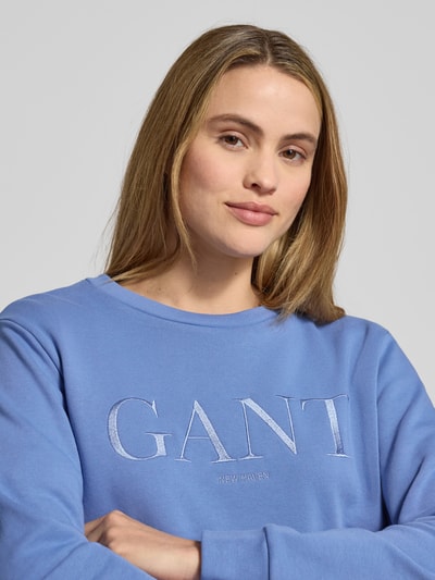 Frauenmodel trägt Sweatshirt mit Label-Stitching und Rundhalsausschnitt von Gant in Blau, reine Baumwolle, Nahaufnahme Oberkörper.