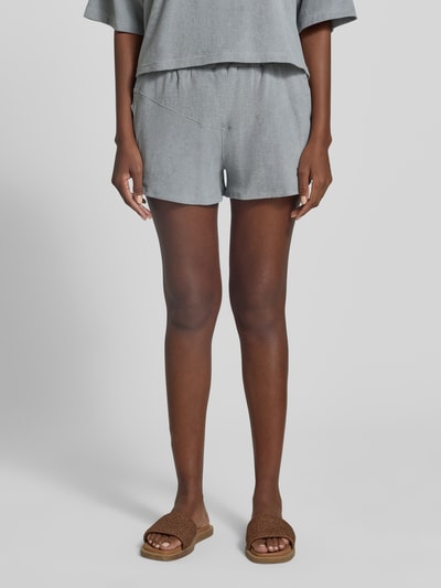 Frauenmodel trägt Straight Fit Shorts mit Tunnelzug Modell 'Saha' von Drykorn, Strukturmuster, elastischer Bund, Farbe Grau, Ganzkörperansicht von vorne.