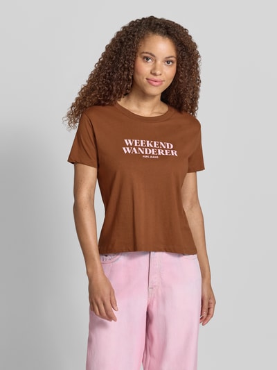 Kobiece modelka nosi damski t-shirt Boxy Fit T-Shirt aus reiner Baumwolle Modell 'CARLA' od Pepe Jeans, jednokolorowy, nadruk z logo, okrągły dekolt, krótki rękaw, dżersej, czysta bawełna, efekt: jednolity kolor. Ganzkörperansicht von vorne.