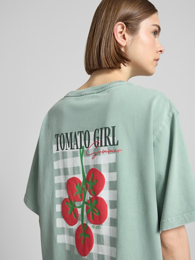 Frauenmodel trägt Oversized T-Shirt mit Label-Stitching von OH APRIL aus reiner Baumwolle, mintgrün, Rückenlänge 69 cm, Detailaufnahme Rückansicht.