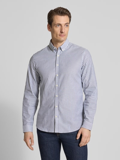 Męski model nosi Relaxed Fit Freizeithemd mit Button-Down-Kragen von Lindbergh, wzór w paski, mieszanka materiałów z dodatkiem streczu, listwa guzikowa, długość tyłu w rozmiarze M: 76 cm, szerokość w rozmiarze M: 44 cm, długość rękawów w rozmiarze M: 64 cm, całość w kolorze biało-niebieskim, widok całej sylwetki z przodu.