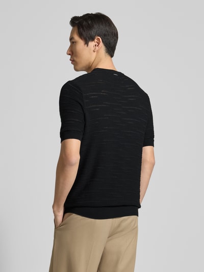 Männermodel trägt schwarzes Strickshirt aus Baumwolle von Antony Morato mit geradem Schnitt und Rundhalsausschnitt, Ganzkörperansicht Rückansicht.