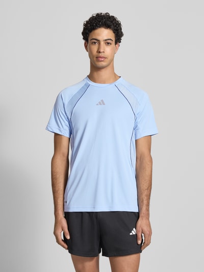 Männermodel trägt T-Shirt mit Label-Print von adidas Training in Hellblau, Regular Fit, Rundhalsausschnitt, Ganzkörperansicht von vorne