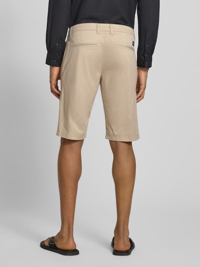 Männermodel trägt Slim Fit Chinoshorts aus Baumwoll-Mix von Tom Tailor, beiges feines Webmuster, Twill, Gesäßtaschen, Ganzkörperansicht Rückansicht.
