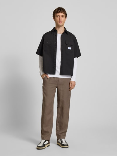 Männermodel trägt Leinenhose mit elastischem Bund Modell 'KARL LAWRENCE' von Jack & Jones, Regular-Fit, braun, reine Leinen, Ganzkörperansicht von vorne. Bundweite bei Größe M: 40 cm, Innenbeinlänge bei Größe M: 75 cm.