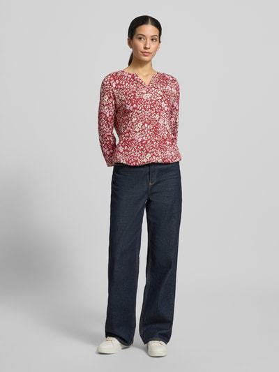 Vrouwenmodel draagt Longsleeve met 3/4-mouw model 'Felicity' van Soyaconcept in rood met witte bloemenprint, slim fit, V-hals, katoen-viscosemix, volledige lichaamsaanzicht van voren.