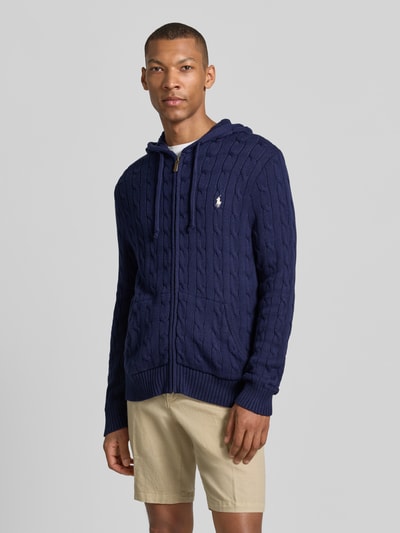 Mężczyzna nosi kardigan rozpinany Regular Fit Strickjacke aus reiner Baumwolle von Polo Ralph Lauren, ciemnoniebieski z fakturą w sploty, Ganzkörperansicht von vorne.
