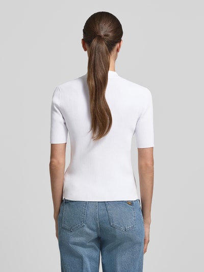 Vrouwenmodel draagt 'Strickshirt mit Schnürung und Umlegekragen' van MICHAEL Michael Kors, wit, viscosemix met stretch, nauwsluitend model, fijnrib, labeldetails, platte kraag, rugaanzicht, detailopname.