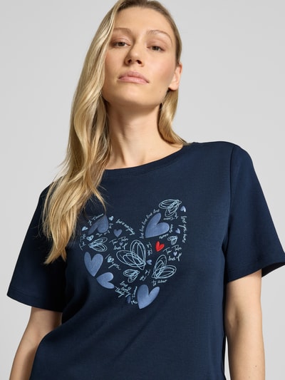 Frauenmodel trägt Relaxed Fit T-Shirt aus reiner Baumwolle von Tom Tailor, Optik: Unifarben, Motiv-Print, Rundhals, Kurzarm, Nahaufnahme Oberkörper.