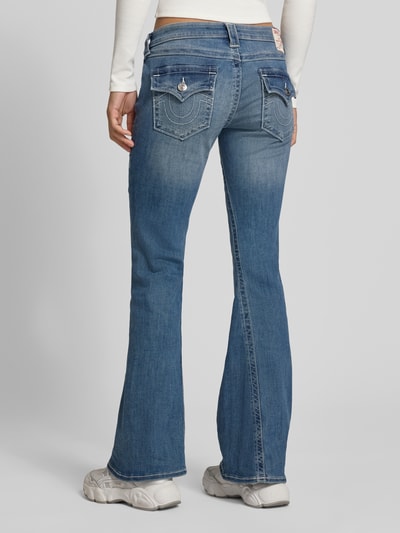 Frauenmodel trägt Flared Jeans Modell 'JOEY' von TRUE RELIGION aus Baumwoll-Mix mit Stretch-Anteil, Damen Low-Rise Flared-Cut, Ganzkörperansicht Rückansicht.