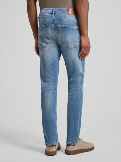 Männermodel trägt Slim Fit Jeans aus Baumwoll-Mix Modell 'DELAWARE' von BOSS Orange, Used Denim, Label Patch, Ganzkörperansicht Rückansicht.