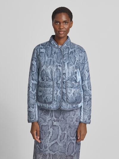 Frauenmodel trägt Regular Fit Jacke in Stepp-Optik mit Stehkragen von Marc Cain, Allover-Schlangen-Print in Blau, Ganzkörperansicht von vorne.