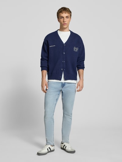 Männermodel trägt Slim Fit Jeans aus Baumwoll-Mix mit Viskose-Anteil Modell 'LOOM' von Only & Sons, hellblau, Denim-Optik, 5-Pocket, Ganzkörperansicht von vorne.