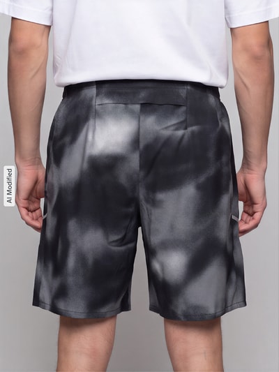 Männermodel trägt Regular Fit Sportshorts mit Dri-FIT-Technologie Modell 'MILER' von Nike, schwarz-graue Muster, Herren Sportshorts, Ganzkörperansicht Rückansicht, KI-modifiziertes Bild.