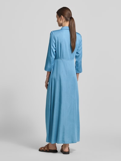 Vrouwenmodel draagt Regular Fit maxi-jurk uit lyocellmix model 'SAVANNA' van YAS, denimlook, met lange mouwen, getailleerd, knoopsluiting, ruglengte maat 36: 135 cm, borstwijdte maat 36: 46 cm, mouwlengte maat 36: 48 cm. Ganzekörperaanzicht rugaanzicht.