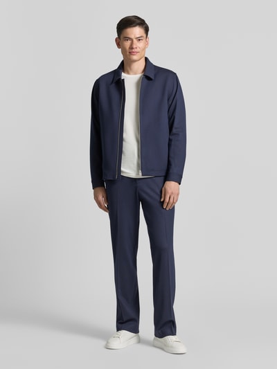 Mannenmodel draagt donkerblauwe Blouson met Zweiwege-Reißverschluss Modell 'BARNABY' van Tiger Of Sweden, straight fit, viscosemix, kentkraag, lengte rug maat M 67 cm, schouderbreedte 46 cm, borstwijdte 54 cm, mouwlengte 65 cm, frontale volledige lichaamsopname.
