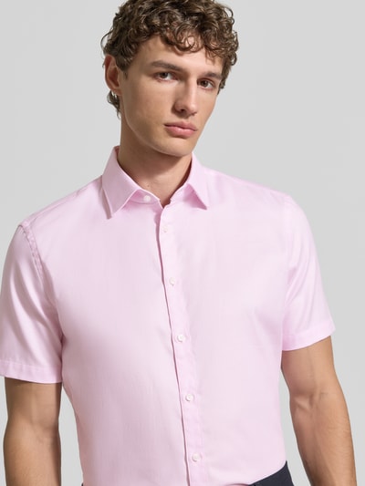 Männermodel trägt Slim Fit Business-Hemd aus katoen met Kentkraag van Jake*s in lichtroze, korte mouw, knoopsluiting, close-up bovenlichaam.