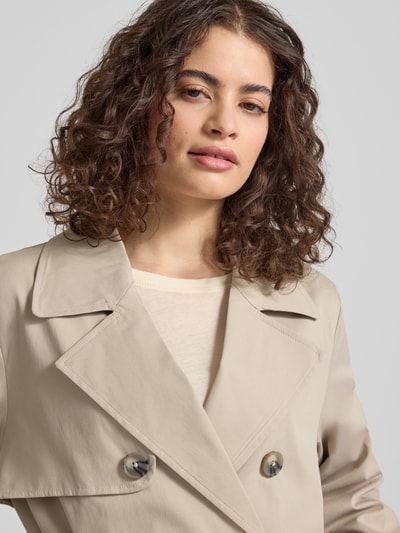 Kobiece modelka nosi Regular Fit Trenchcoat mit Reverskragen Modell 'DISA LIFE' od Only, jednolity kolor, podwójny rząd guzików, pasek w talii, długie rękawy z regulowanym paskiem, boczne kieszenie, materiał gładki, krój regular fit, widok na górną część ciała z przodu