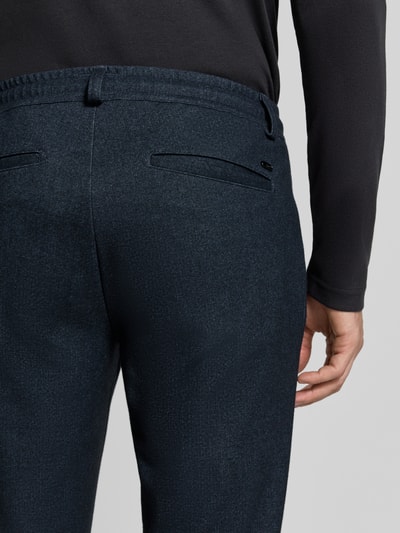 Männermodel trägt dunkelblaue Tapered Fit Jogpants mit Viskose-Anteil Modell 'Phil KBE' von Brax, Herren Schmale Hose, Nahaufnahme Rückansicht.