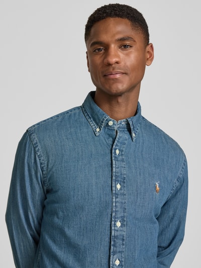 Männermodel trägt Custom Fit Jeanshemd aus reiner Baumwolle von Polo Ralph Lauren in klassischem Denim-Blau mit Logo-Stitching, Nahaufnahme Oberkörper.