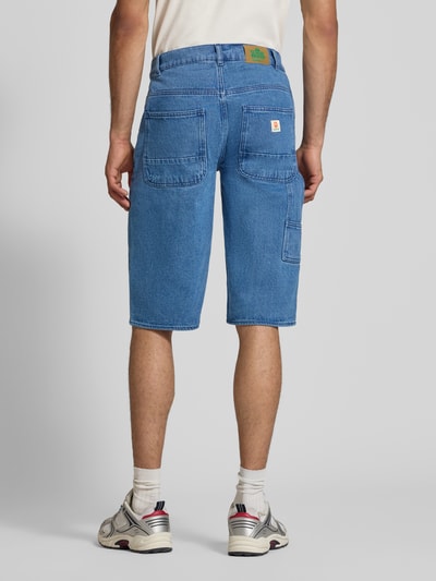Männermodel trägt Loose Fit Denim-Bermudas Modell 'MIGS SUN FLAKE' von Blend in Blau mit Eingrifftaschen, Reine Baumwolle, Ganzkörperansicht Rückansicht.