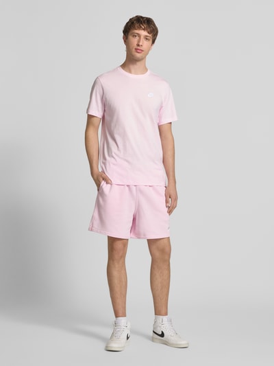 Männermodel trägt Shorts mit Label-Stitching und elastischem Bund von Nike in Rosa, Baumwoll-Mix, Relaxed-Fit, Ganzkörperansicht von vorne.