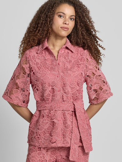 Frauenmodel trägt Bluse aus Spitze mit Bindegürtel von Jake*s Collection in Rosa mit Kentkragen, tailliertem Schnitt, Knopfleiste, Nahaufnahme Oberkörper.