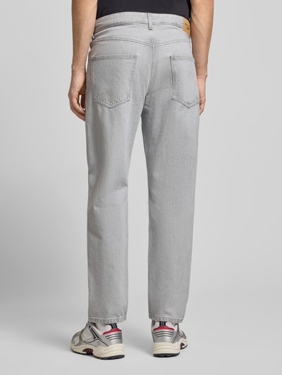 Männermodel trägt Loose Fit Jeans aus reiner Baumwolle Modell 'RUNNE' von Marc O’Polo Denim, graue Denim-Optik, 5-Pocket-Design, Ganzkörperansicht Rückansicht.