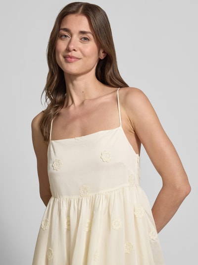 Frauenmodel trägt Midikleid aus Lyocell-Mix Modell 'Cherish' von SUNCOO PARIS mit floralen Zierbesätzen, Nahaufnahme Oberkörper.
