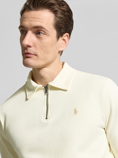 Männermodel trägt Regular Fit Sweatshirt aus reiner Baumwolle von Polo Ralph Lauren, Optik: Unifarben, Logo-Detail, Polokragen, V-Ausschnitt, Langarm, Bündchen: Gerippt, Materialverarbeitung: Sweat, Farbe hell, glatte Textur, Nahaufnahme Oberkörper.