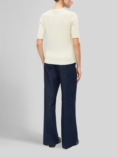 Frauenmodel trägt Regular Fit Pullover aus Viskose-Mix von s.Oliver BLACK LABEL in Creme und dunkelblaue Hose, Ganzkörperansicht Rückansicht.