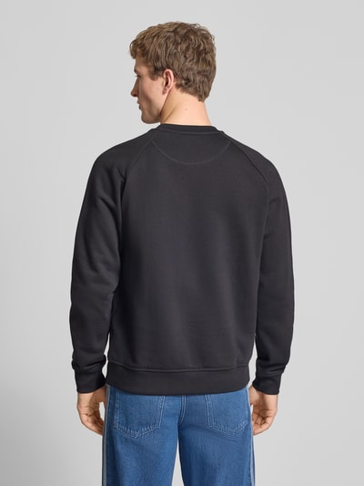 Męski model nosi Regular Fit Sweatshirt aus Baumwoll-Mix od adidas Originals, gładki bawełniany materiał, czarny kolor, widok całej sylwetki z tyłu.
