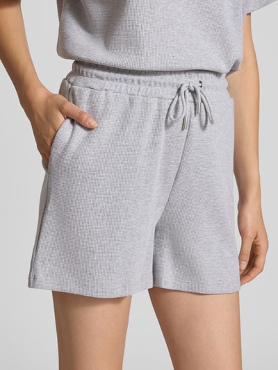 Vrouwenmodel draagt Shorts met structuurpatroon Model 'Elow' van OH APRIL, puur katoen, regular fit, elastische band met tunnelkoord, bandwijdte maat S 39 cm, binnenbeenlengte maat S 9 cm, lichtgrijs, zachte textuur, detailopname heupen en bovenbenen.