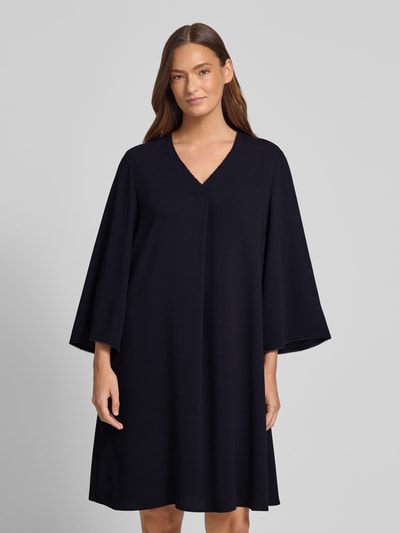 Kobiece model nosi Knielanges Kleid mit V-Ausschnitt von Windsor, linia A, długość do kolan, lejący materiał, dekolt w serek, frędzle, długość tyłu w rozmiarze 36: 98 cm, szerokość w rozmiarze 36: 46 cm, długość rękawów w rozmiarze 36: 55 cm, całkowity widok z przodu
