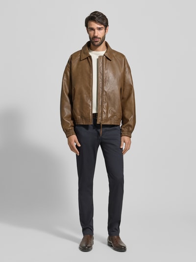 Männermodel trägt Slim Fit Chino aus Baumwoll-Mix Modell 'BLEECKER' von Tommy Hilfiger, Optik: Unifarben, Ganzkörperansicht von vorne.