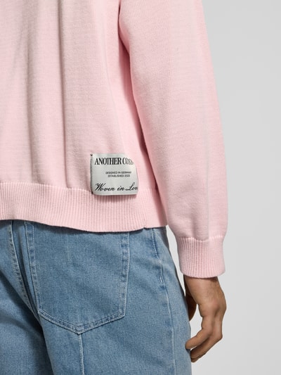 Männermodel trägt Strickpullover mit gerippten Abschlüssen von ANOTHER COTTON LAB, reine Baumwolle, lockerer Schnitt, Nahaufnahme Oberkörper.