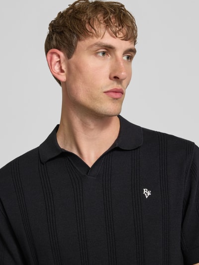 Männermodel trägt Regular Fit Poloshirt mit Logo-Stitching von REVIEW aus Reine Baumwolle, Loch-Stitching, Kurzärmelig, Nahaufnahme Oberkörper. Rückenlänge bei Größe M: 56 cm.