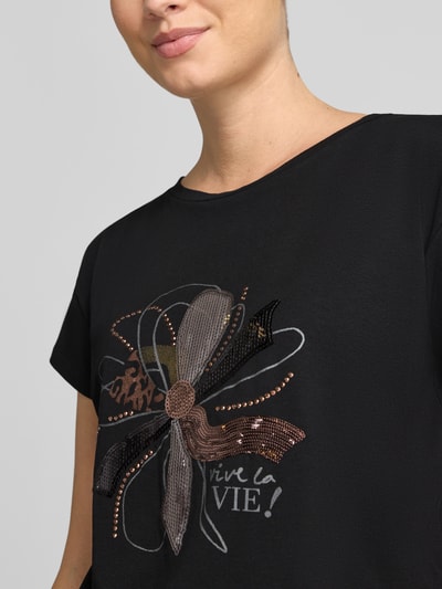Frauenmodel trägt Regular Fit T-Shirt aus Baumwoll-Modal-Mix von MORE & MORE mit Statement-Print, schwarze Farbe, Nahaufnahme Oberkörper.