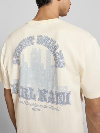 Männermodel trägt Oversized T-Shirt mit rückseitigem Print von KARL KANI aus Reine Baumwolle, Label-Stitching, Rundhalsausschnitt, Rückseite, Nahaufnahme Oberkörper.