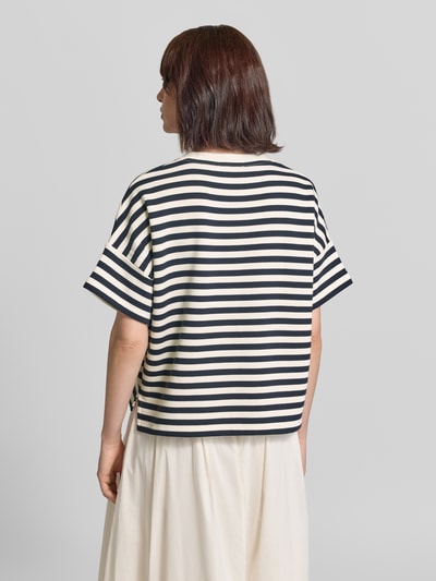 Frauenmodel trägt Boxy Fit T-Shirt im Allover-Look von Closed in Schwarz-Weiß mit Rundhalsausschnitt aus reiner Baumwolle, Ganzkörperansicht Rückansicht.