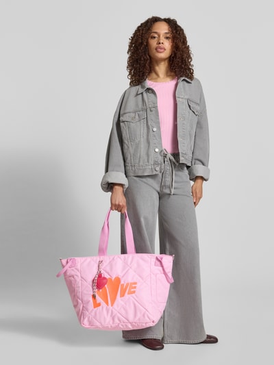 Kobiece model nosi różową torbę shopper z pikowaniem i haftem model 'Love' od miss goodlife, główna przegroda, zapięcie na magnes, uchwyt, odpinany pasek na ramię, szerokość w rozmiarze 1: 33 cm, długość w rozmiarze 1: 59 cm, głębokość w rozmiarze 1: 22 cm, długość paska na ramię w rozmiarze 1: 58 cm, widok całej sylwetki od przodu.