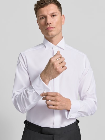Männermodel trägt Modern Fit Business-Hemd mit verdeckter Knopfleiste von OLYMP aus reiner Baumwolle Kentkragen Nahaufnahme Oberkörper.