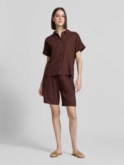 Frauenmodel trägt Relaxed Fit Bluse aus Leinen-Viskose-Mix Modell 'Lava' von FREE/QUENT in Braun, mit Hemdblusenkragen und Knopfleiste, Ganzkörperansicht von vorne.