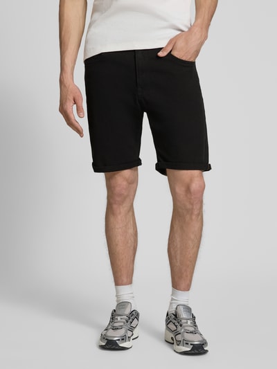 Männermodel trägt schwarze Jeansshorts mit Umschlag und Eingrifftaschen Modell 'RICK ALLEN' von Jack & Jones im Regular Fit, Baumwoll-Elasthan-Mix, mit sichtbarer Bundweite, Ganzkörperansicht von vorne.